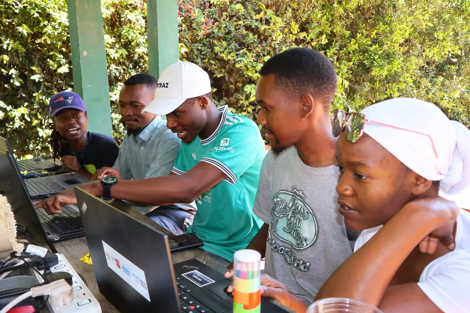 A team works together around laptops at Impact Hub Harare.