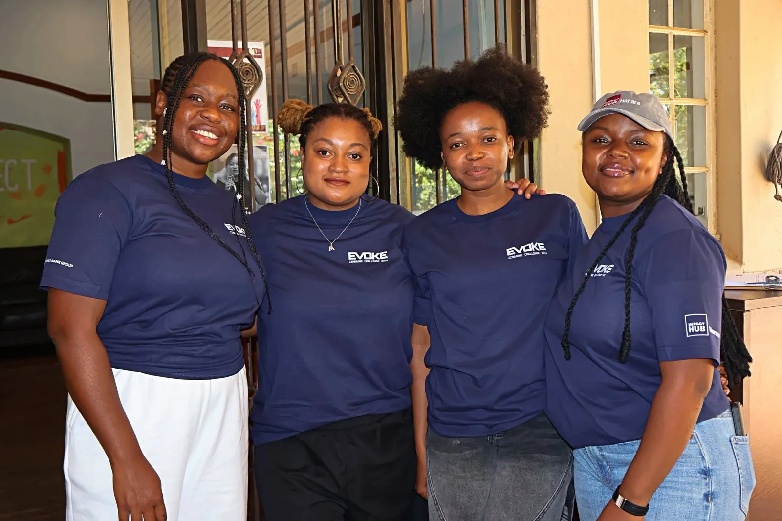 Four participants in Evoke T-shirts pose together.